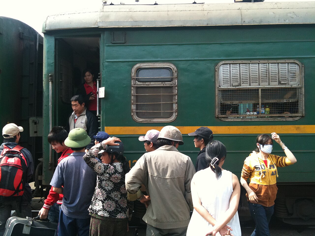 Passengers boarding a Vietnam Railways (VNR) passenger train car at the platform