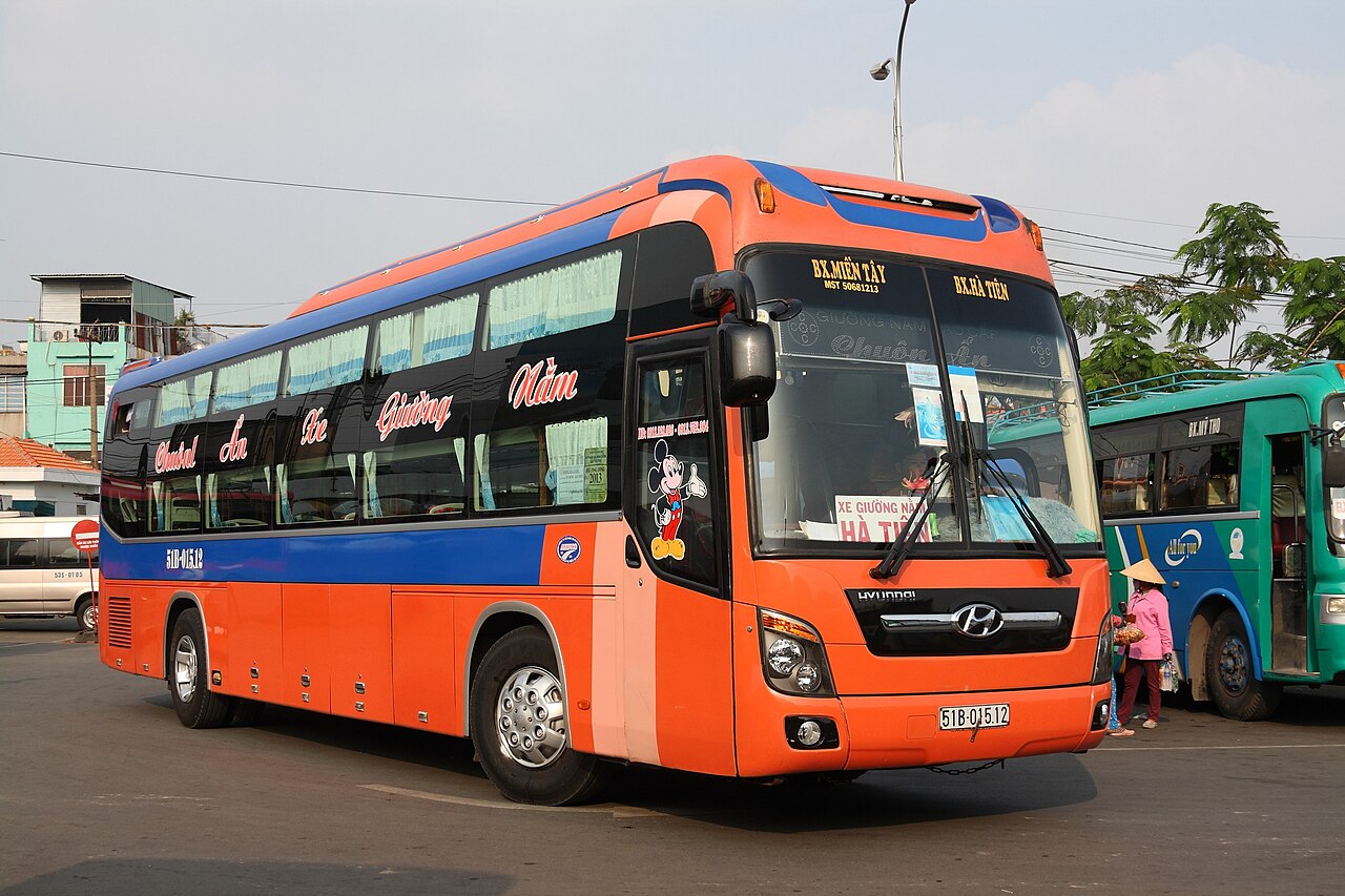 Exterior of a modern double-decker sleeper bus on an intercity road in Vietnam