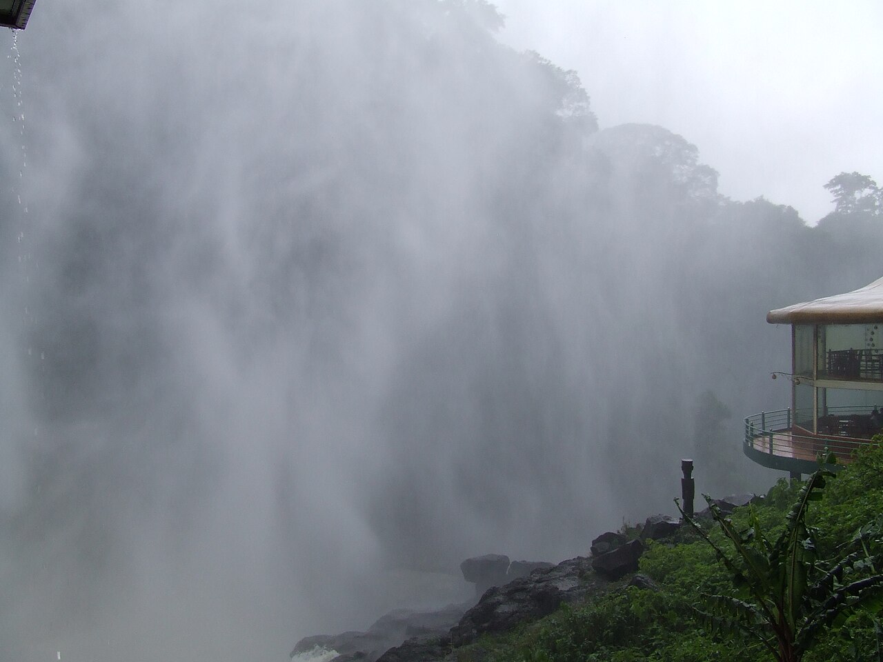 Towering cascade and misty gorge of Dambri Waterfall surrounded by rainforest in Bao Loc
